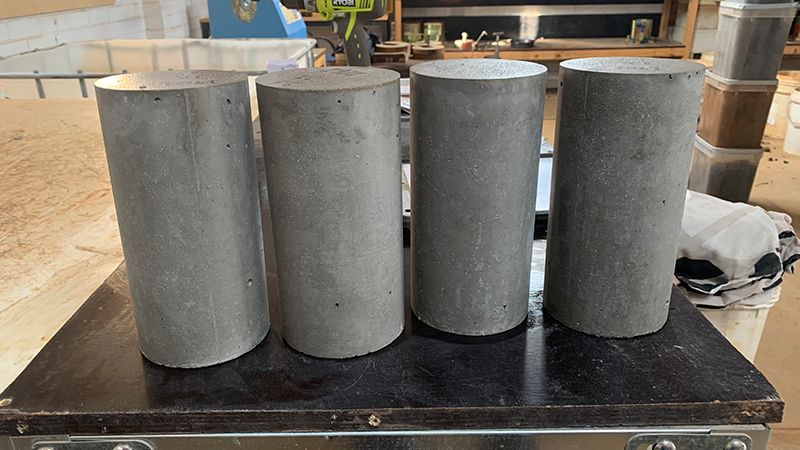 Multiple cured cylindrical concrete specimens awaiting concrete compression testing at RMA Soils in Toowoomba