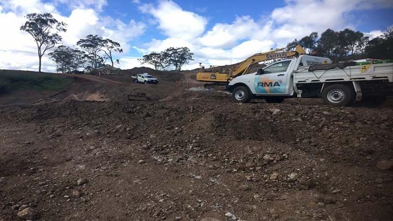 RMA Soils + Geotechnical vehicles and an excavator parked on site for a slope stability assessment