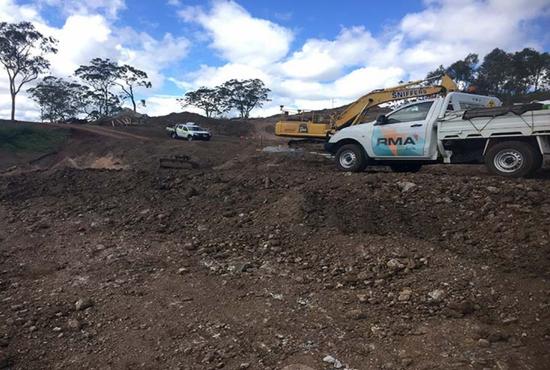 RMA Soils + Geotechnical vehicles and an excavator parked on site for a slope stability assessment